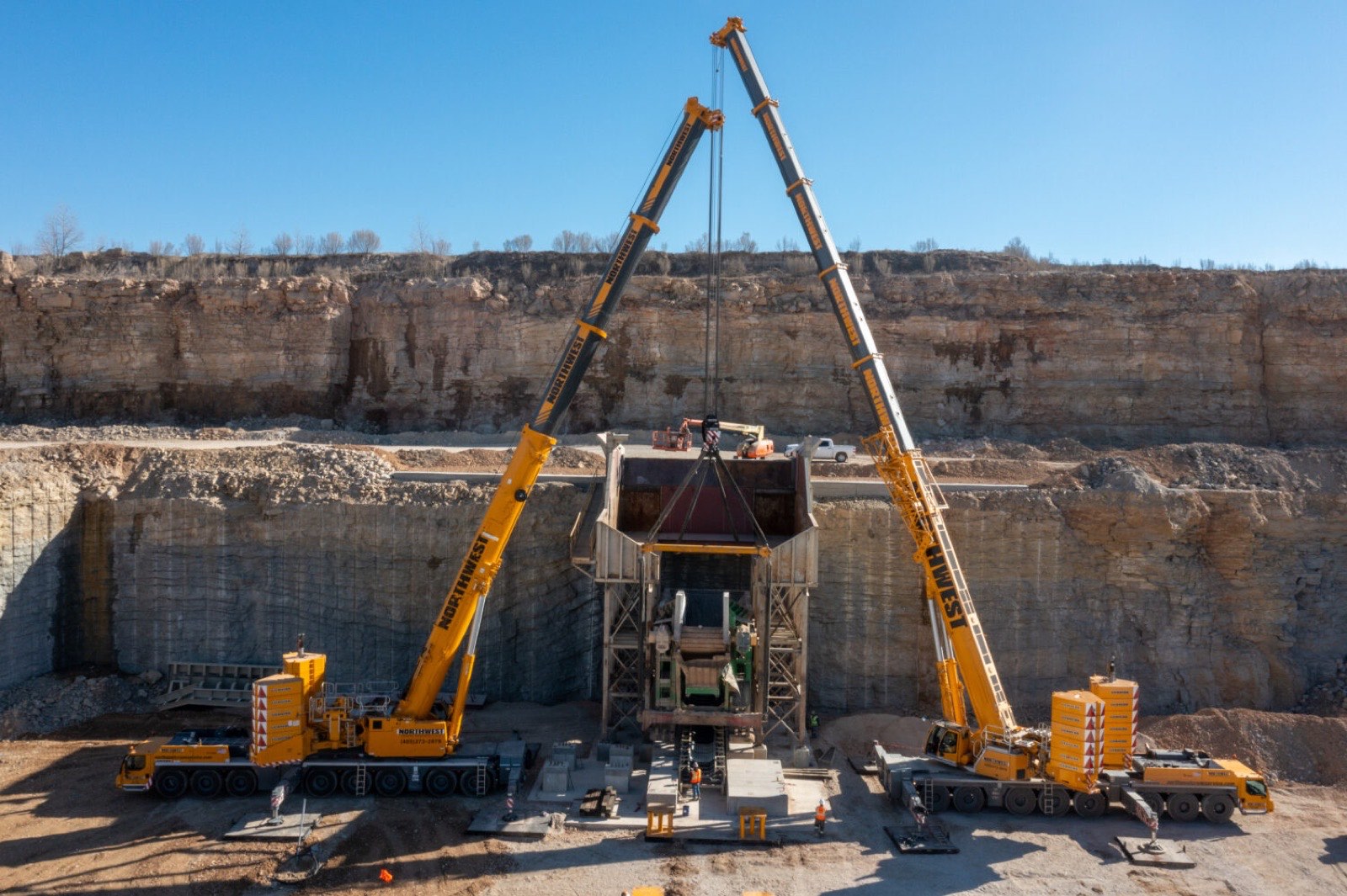 Two Northwest all-terrain cranes making a tandem lift in a rock quarry