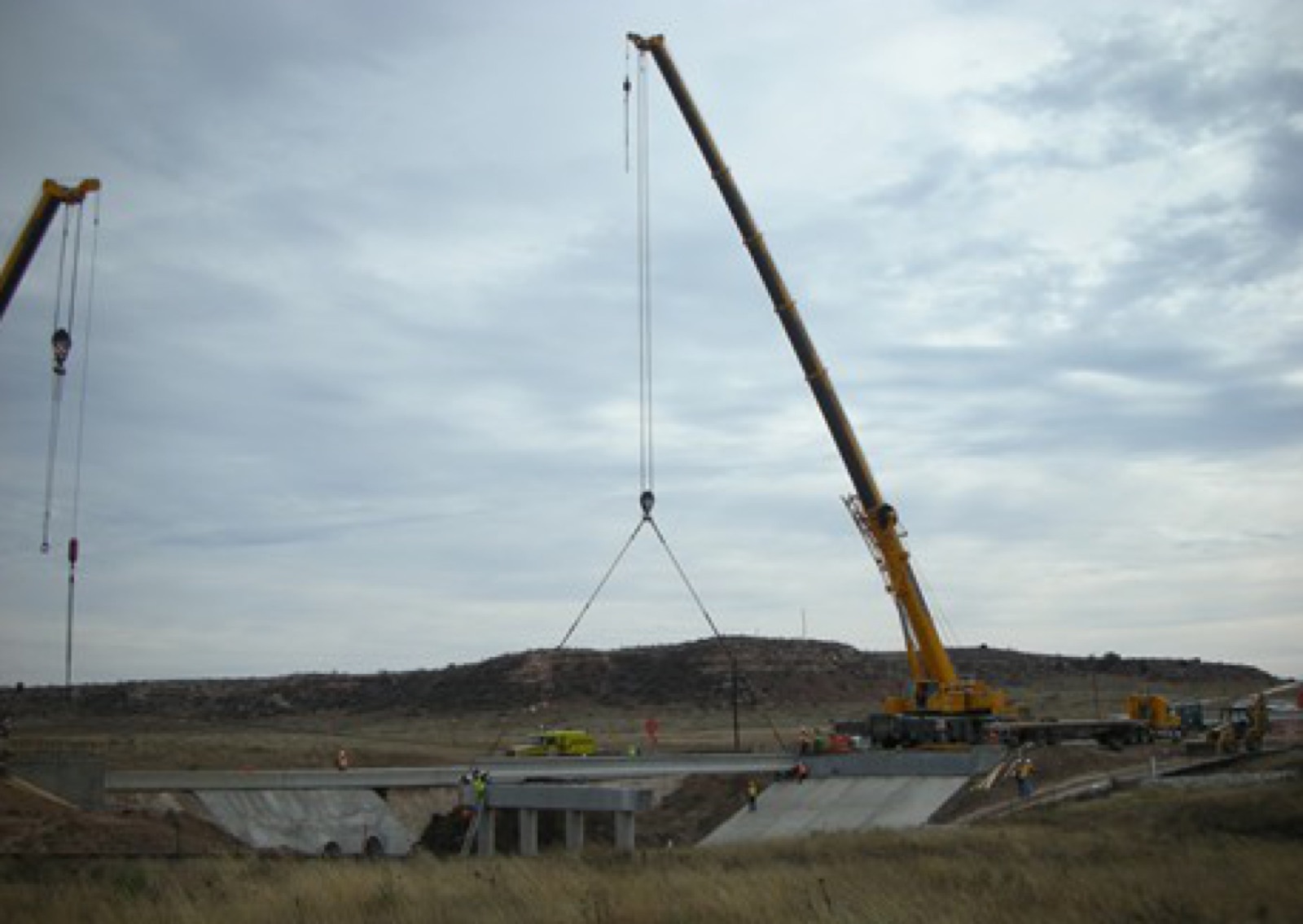 Northwest crane setting a bridge beam over railroad tracks
