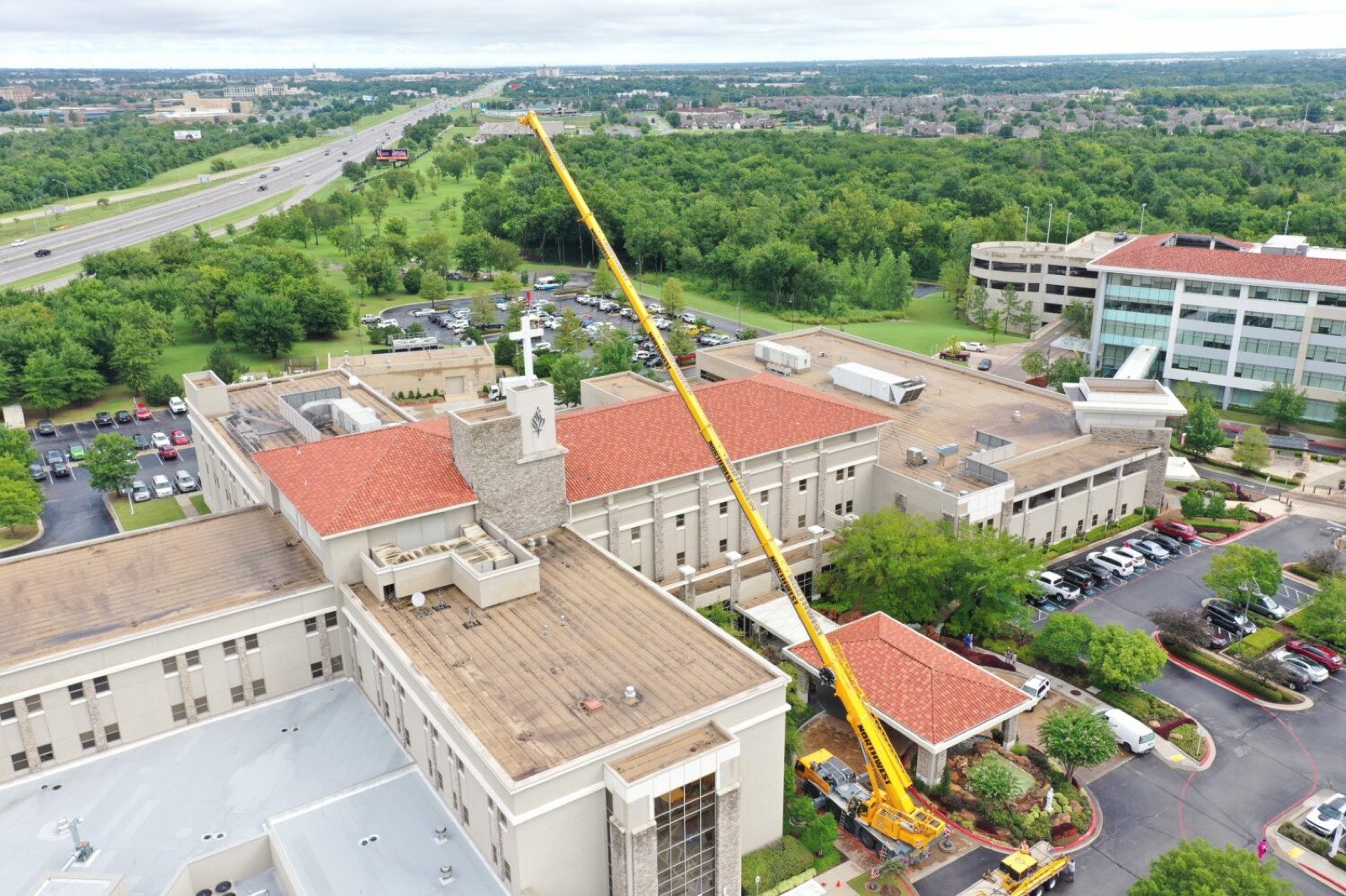 Aerial view of a Northwest all-terrain crane working on large-format signage in Tulsa