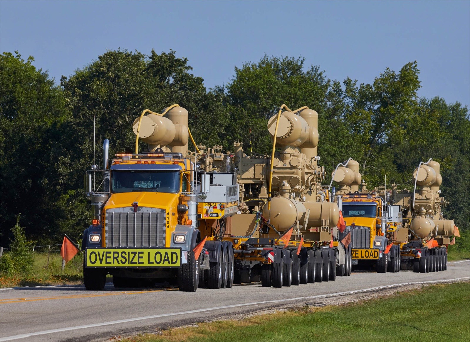Oversize load moving over the road with escorts
